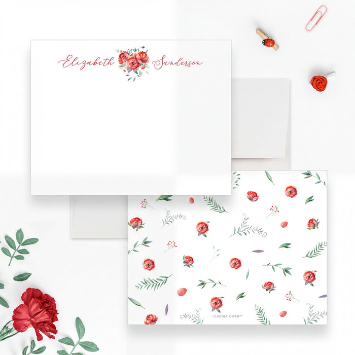 a white envelope with a floral pattern and a red rose, along with some red rose petals and a red rose clip on a white background.