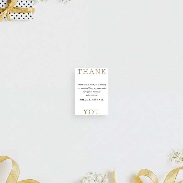 a white card with text on it, placed against a white background with a gift box and some flowers.