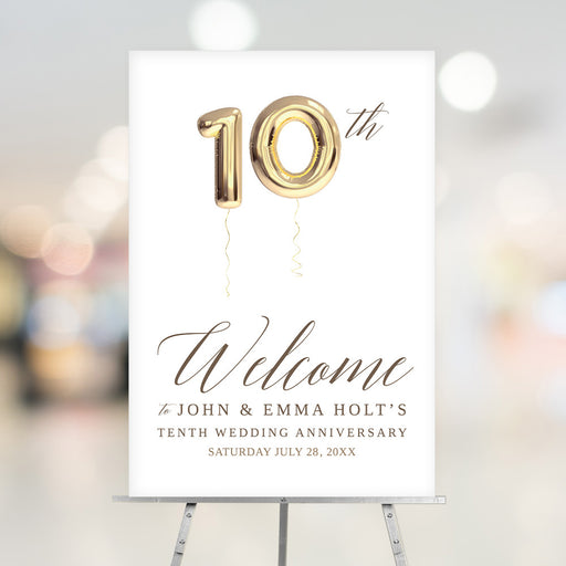 10th wedding anniversary welcome sign featuring large gold balloon numbers and elegant lettering displayed on an easel.