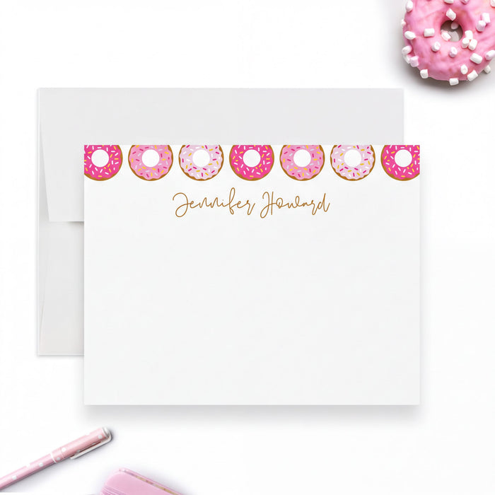 a white card with a personalized message, a pink donut, and a pen on a white background.