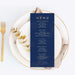 Navy blue menu card on a white plate with gold fork and decorative elements