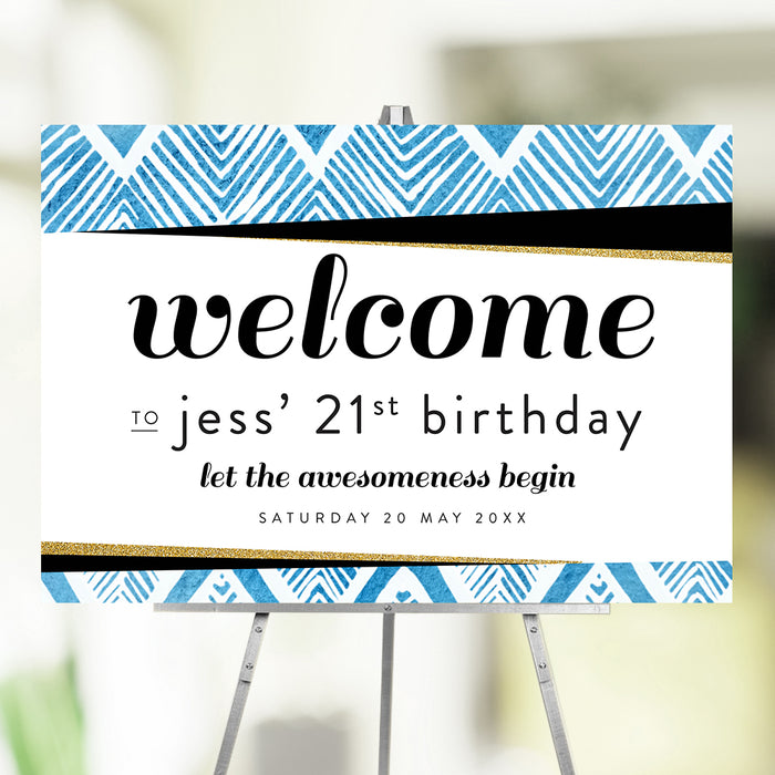 Blue geometric 21st birthday welcome sign displayed on an easel for a milestone birthday celebration.