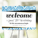 Blue geometric 21st birthday welcome sign displayed on an easel for a milestone birthday celebration.