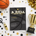 a basketball-themed party invitation with a basketball, trophy, and confetti surrounding it.