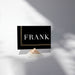 a black rectangular card with the word "FRANK" written on it, placed on a white surface.