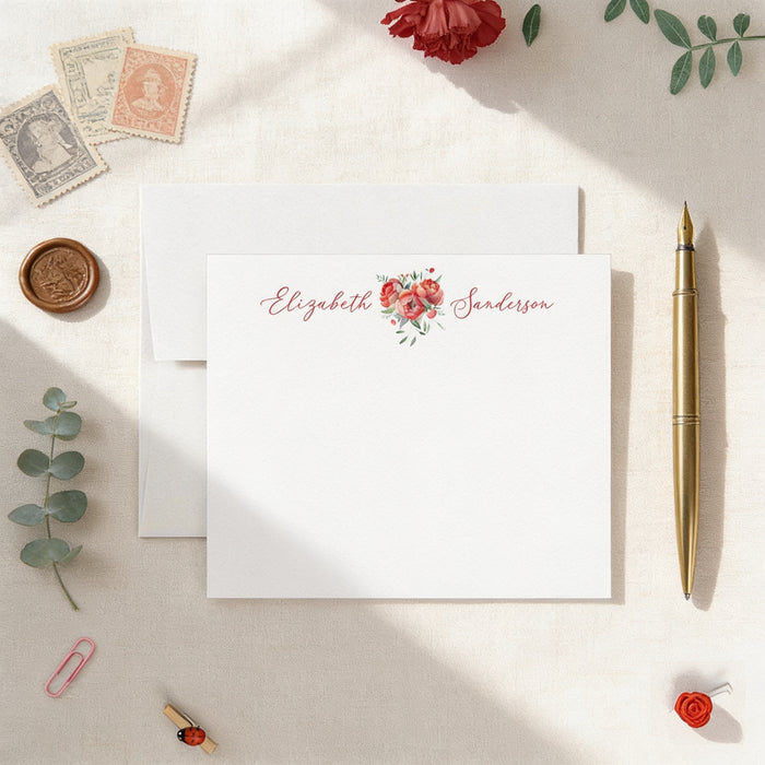 a white card with a floral design, surrounded by various stationery items such as a pen, a rose, and a stamp.