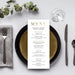 a table setting for a restaurant, featuring a menu, a fork, a knife, a glass, and a plant.