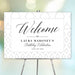 white geometric birthday welcome sign with elegant black lettering displayed on an easel for a milestone birthday celebration.