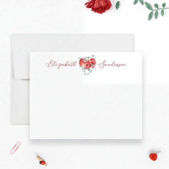 a white card with a floral design and the name "Elizabeth" written on it, along with a red rose and some green leaves.