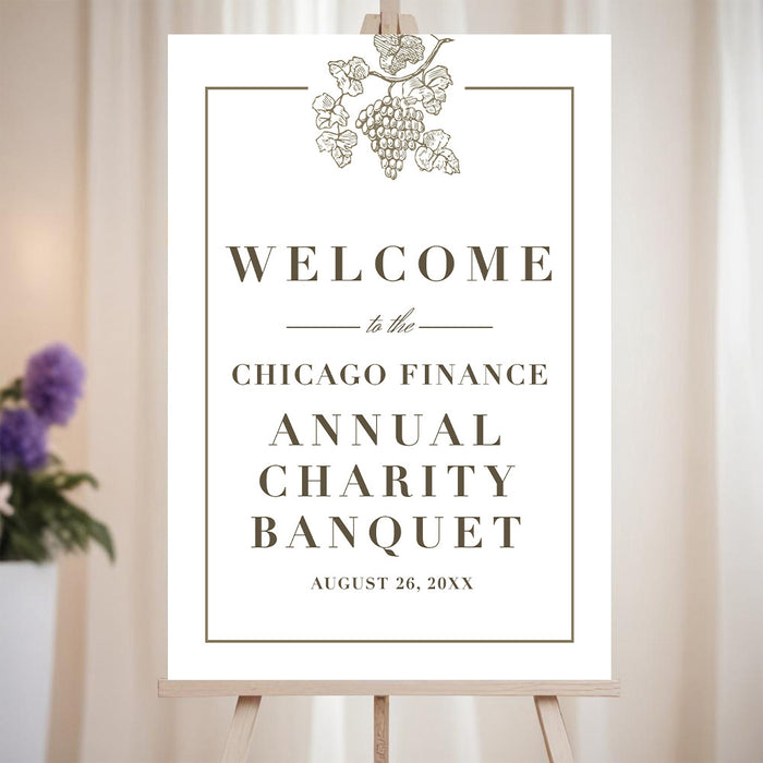 Elegant welcome sign with grapevine illustration for wine-themed charity banquet celebrations.