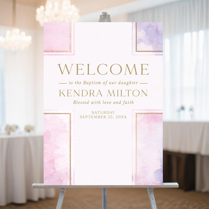 Pink watercolor baptism welcome sign for a christening celebration displayed on an easel at a religious event.