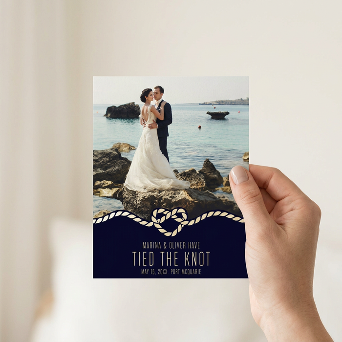 Beach wedding announcement held in hand