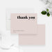 Beige wedding thank you cards with bold black thank you lettering and personalized names on the front and a plain beige reverse.