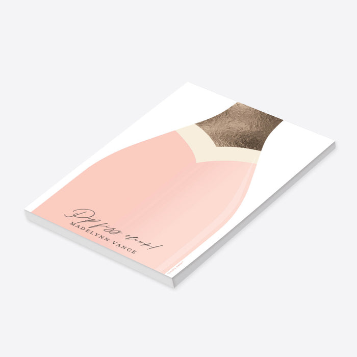 Blush pink champagne bottle notepad with “Pop Fizz Clink!” text, personalized with a name, making it a custom stationery gift or party favor.-side