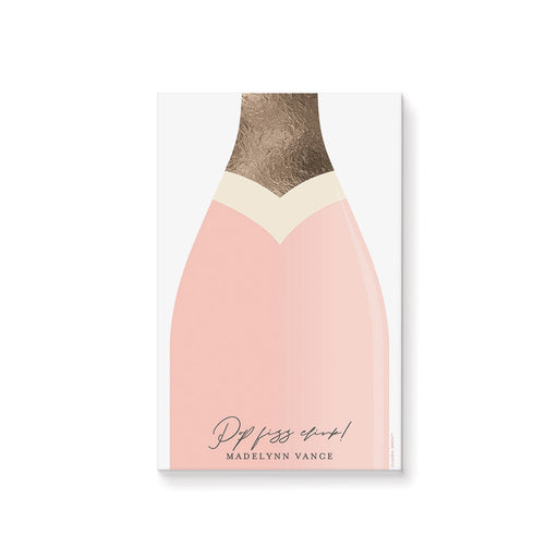 Blush pink champagne bottle notepad with “Pop Fizz Clink!” text, personalized with a name, making it a custom stationery gift or party favor.