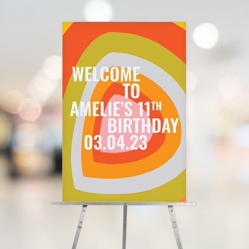 Retro-inspired welcome sign featuring an abstract pattern in bold orange, yellow, green, pink, and grey for kids’ 7th to 15th birthday parties