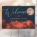 Howl at the Moon birthday welcome sign featuring a glowing full moon, flying bats, orange clouds, and custom birthday details for a spooky celebration.