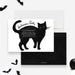 Halloween party invitation featuring a large black cat illustration with yellow eyes on a white background. The event details are written across the cat’s body in a playful font, surrounded by small black bat graphics, creating a fun and spooky theme.