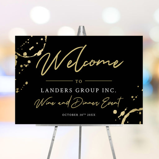 Black corporate wine dinner welcome sign with gold wine glass ring accents, script lettering, company name and event date