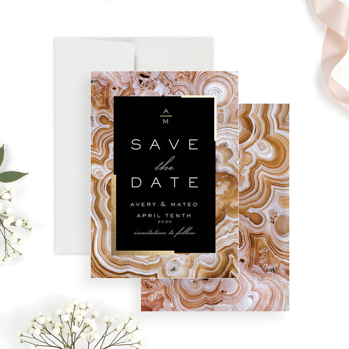 Geode wedding save the date card featuring a black center panel framed by a gold agate pattern in a modern elegant design-front-back
