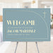 Blue baptism welcome sign with gold cross and modern arch design displayed on an easel for a christening or baby dedication celebration.