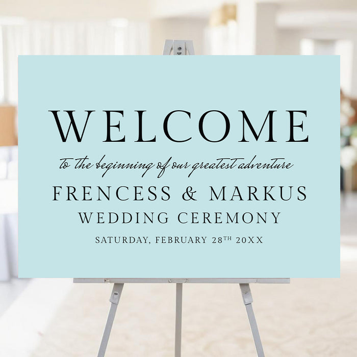 Modern blue wedding welcome sign with elegant typography displayed on easel for ceremony entrance.
