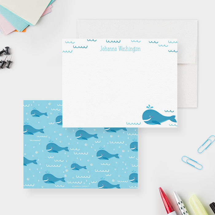 Personalized blue whale note card front and back, with a smiling whale, waves, a printed name and a repeating whale pattern on blue.