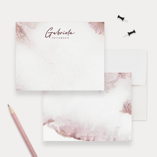 Personalized blush pink watercolor note card front and back, with burgundy script name lettering and white envelopes.