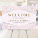 blush pink wedding welcome sign with jewel-inspired geometric frame, refined lettering, and personalized wedding details