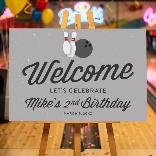 bowling birthday welcome sign with bowling pins, bowling ball, gray background, and custom birthday party details on an easel