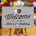 bowling birthday welcome sign with bowling pins, bowling ball, gray background, and custom birthday party details on an easel