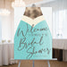 Bridal shower welcome sign featuring a champagne bottle illustration, elegant decor for a bride-to-be celebration.