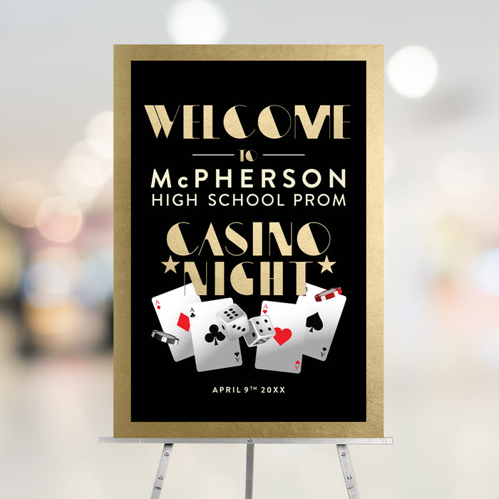 Black and gold welcome sign for the casino night, featuring playing cards, dice, and poker chips.