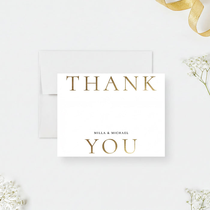 A white card with the text "THANK MILLA & MICHAEL YOU" printed on it, placed on a white background with some flowers and a ribbon visible in the background.