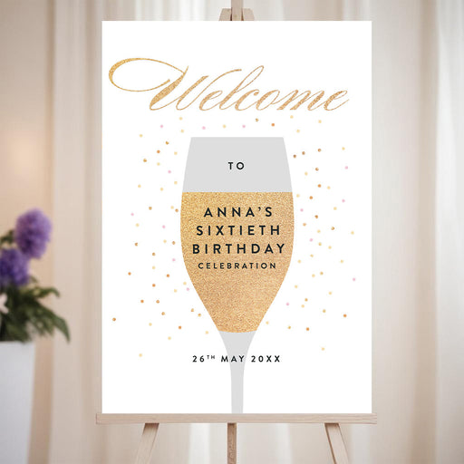 Elegant champagne birthday welcome sign with confetti dot design and celebration lettering displayed on an easel for a party entrance.