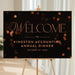 corporate annual dinner welcome sign with elegant lettering on a black background and warm confetti accents for a business event