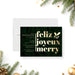 Elegant holiday party invitation featuring gold "Feliz, Joyeux, Merry" lettering, evergreen foliage background, holly accents, and personalized event details-front