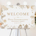 corporate holiday party welcome sign with gold-toned pine branches, pinecones, snowflakes, and elegant winter botanical border
