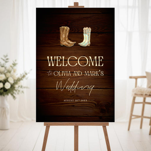 Rustic western wedding welcome sign with cowboy boots illustration on a dark wood background displayed on an easel.