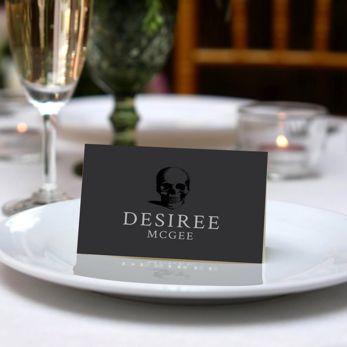 Death to Your 20s folded place card with skull artwork shown on a table setting.