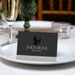 Death to Your 20s folded place card with skull artwork shown on a table setting.