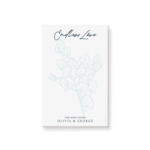 personalized botanical notepad with pale blue foliage design, elegant script lettering, and the newlyweds' name