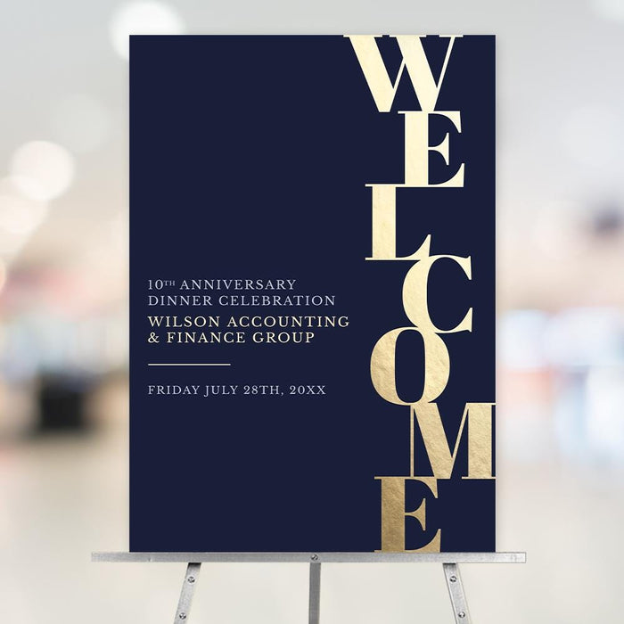 Editable navy and gold-effect business event welcome sign with oversized vertical WELCOME lettering displayed on an easel