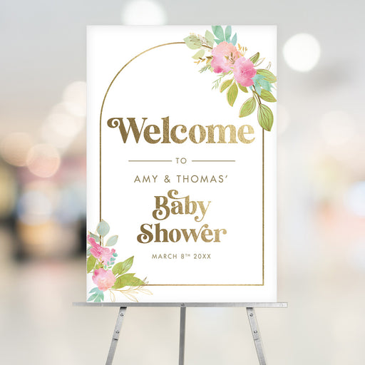 Custom floral baby shower welcome sign featuring pastel watercolor flowers, gold text, and an arch frame, displayed on an easel.