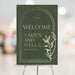Green and gold botanical wedding welcome sign with an elegant frame, customizable details, perfect for garden weddings and receptions.