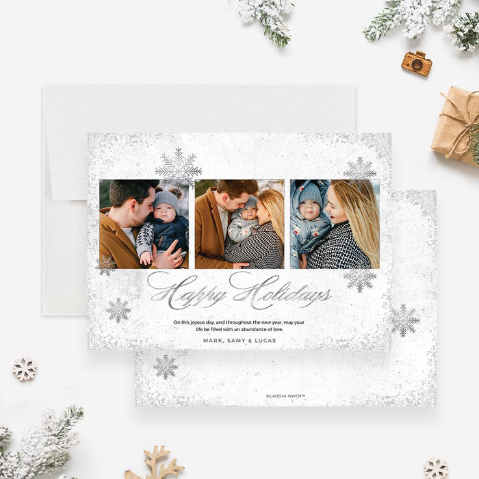 Elegant silver holiday photo card featuring three family photos, snowflake accents, and “Happy Holidays” script text on white background.
