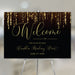 Elegant prom welcome sign with sparkling hanging lights on black background for gala entrance display