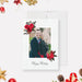 Elegant holiday photo card featuring a couple’s picture framed by red floral illustrations, with “Happy Holidays” text in script