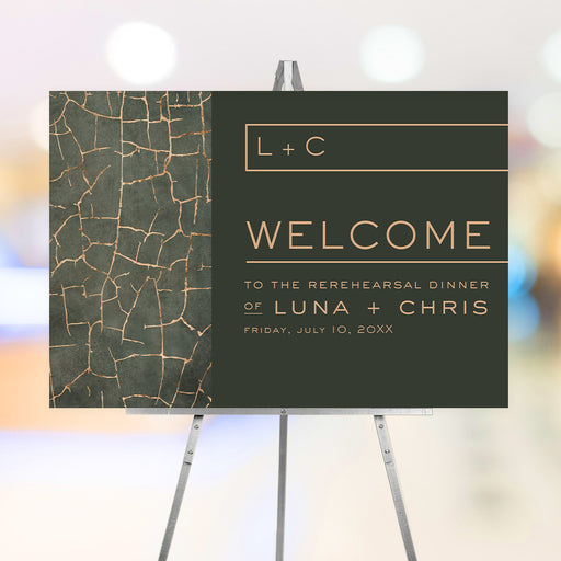 Elegant green and gold rehearsal dinner welcome sign on easel, personalized with couple’s initials and event details.