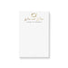 A personalized notepad with white background and gold text that reads 'Wine and Dine' and includes a name